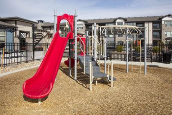Outdoor children's playground with red slide and monkey bars